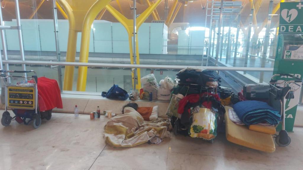 Una de las personas que vive en el Aeropuerto de Barajas con sus cosas.