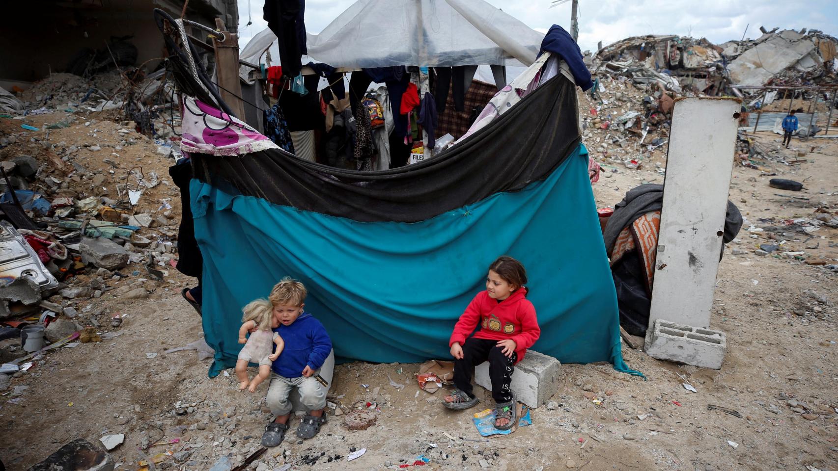 Niños palestinos juegan junto a los escombros en Gaza.
