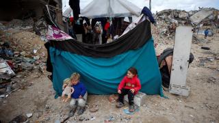 Niños palestinos juegan junto a los escombros en Gaza.