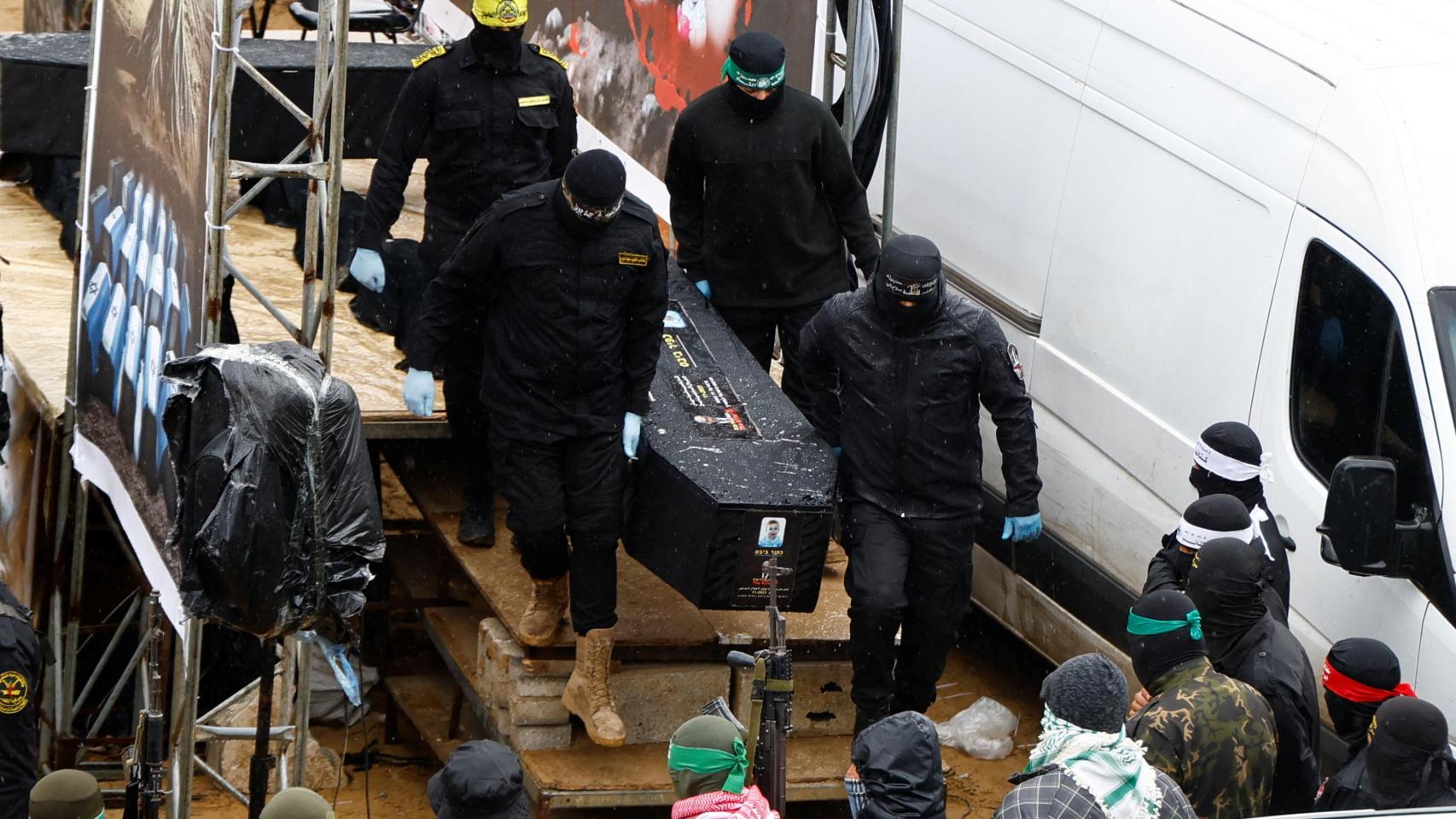 MIlicianos de Hamás con uno de los cadáveres entregados a Israel.