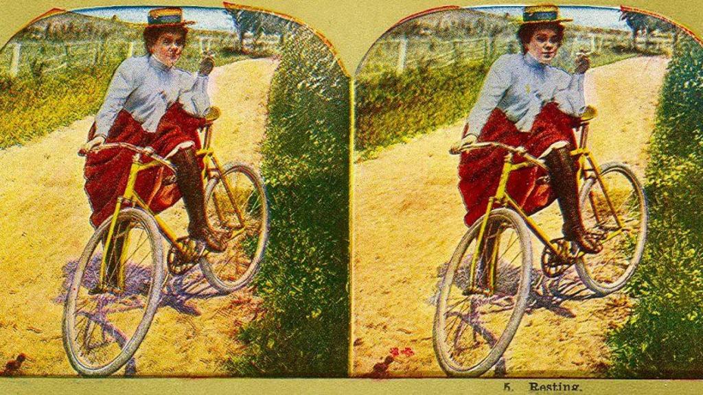 Mujer con un cigarrillo en la mano y en bicicleta.