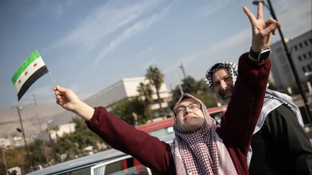Una mujer celebra en las calles de Damasco la caída de Al Asad.