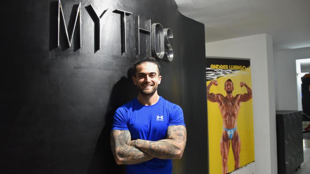 El dueño del Mythos Gym y un cartel de una competición