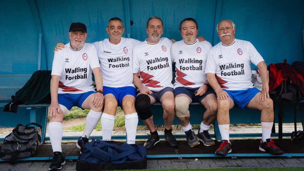 Jugadores de walking football en el banquillo del campo del Rayo Majadahonda.