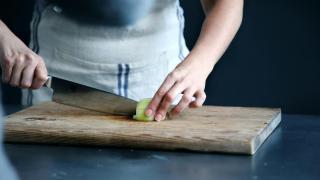 Una mujer cortando verduras, en una imagen de archivo.
