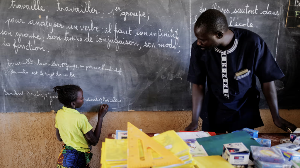 Un profesor de Burkina Faso, en el aula con una alumna.