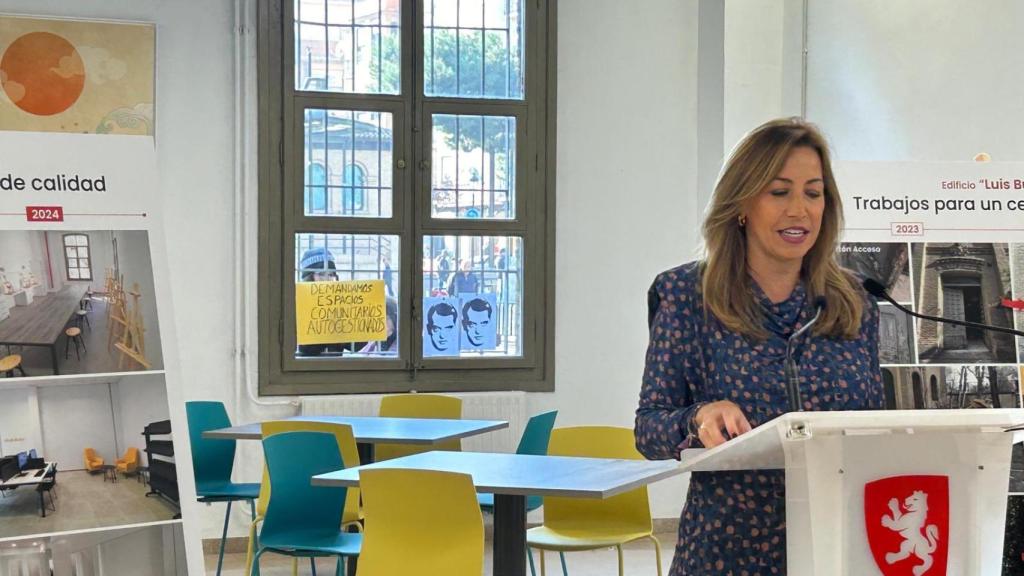 Una joven con carteles reivindicativos en la ventana del comedor, el día de la inauguración del nuevo espacio.