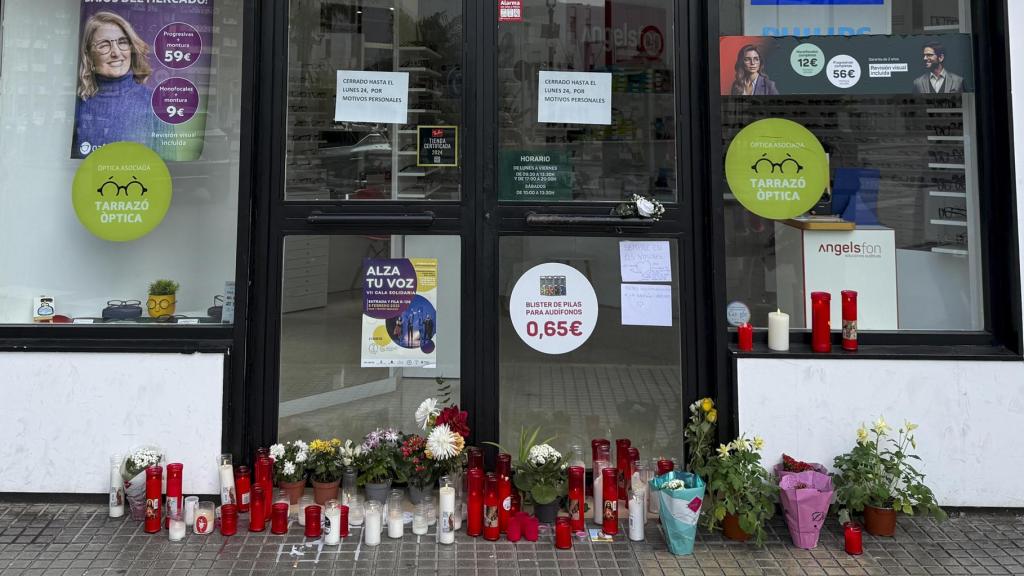 Velas y flores colocados por vecinos en la puerta de la óptica que el exalcalde de Gandia había abierto recientemente.