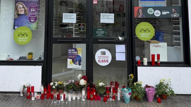 Velas y flores colocados por vecinos en la puerta de la óptica que el exalcalde de Gandia había abierto recientemente.