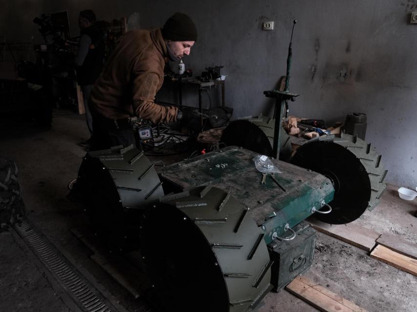 Un ingeniero ucraniano de la Brigada Khartiia repara uno de los drones terrestres que están utilizando en el frente de combate.