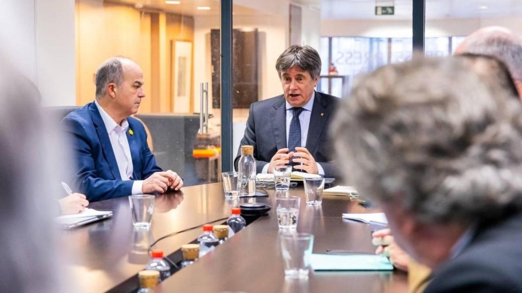 El presidente de Junts, Carles Puigdemont, en una reunión del partido en Bruselas el pasado enero junto a Jordi Turull.