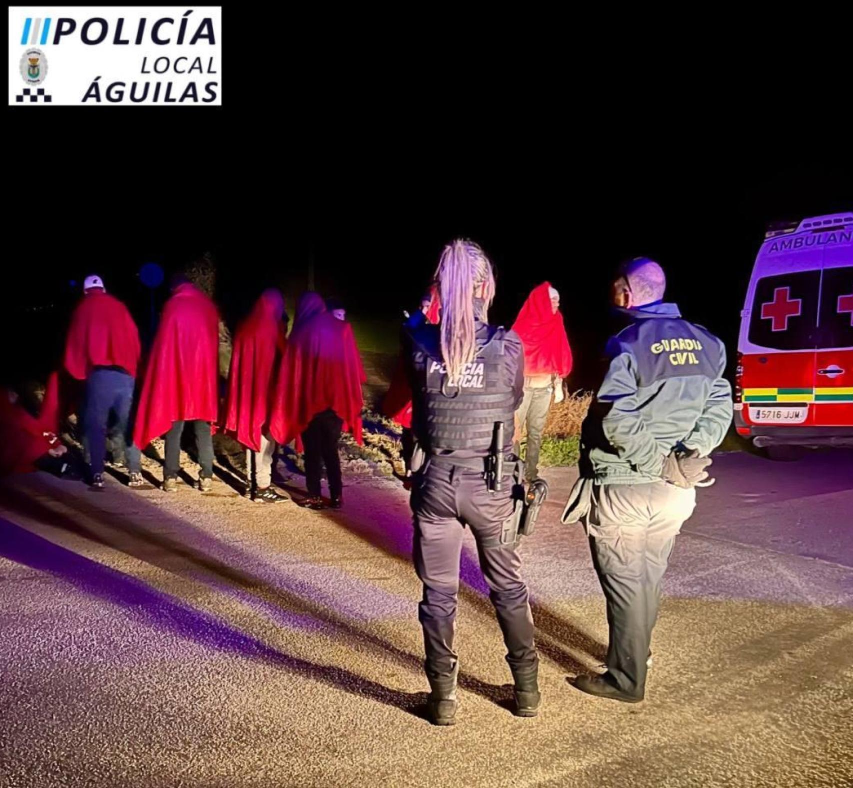 Dos agentes, tras el rescate de los inmigrantes en la playa de El Rafal en Águilas.