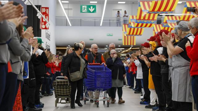 Empleados y clientes del hipermercado Carrefour de Alfafar aplauden a la entrada durante su reapertura. Efe / Ana Escobar