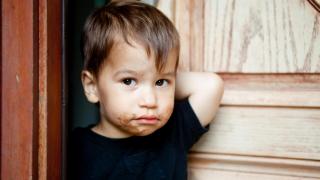 Un niño con la boca llena de chocolate.