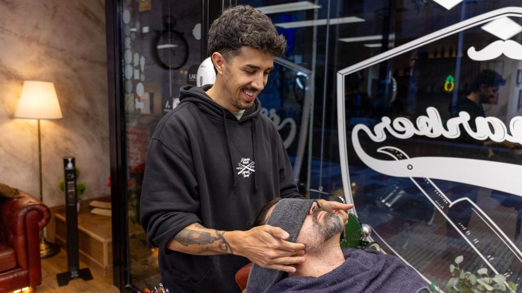 Javier Pantoja arreglando la barba de uno de sus clientes.