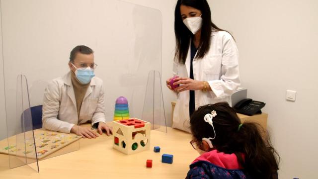 Una niña con implantes cocleares en una consulta.