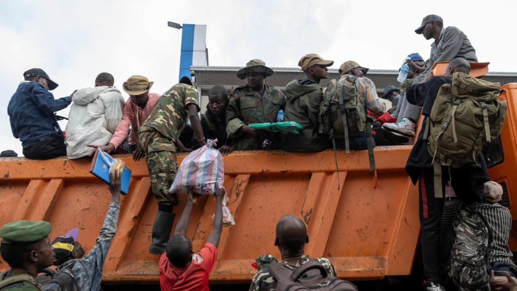 Soldados que se rindieron en Bukavu después de que la ciudad fuera tomada por rebeldes del M23, suben a camiones en el puerto de Goma , antes de partir hacia Rumangambo, en la provincia de Kivu del Norte.