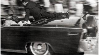 Clint Hill subido a la limusina donde iba John F. Kennedy el día de su asesinato.