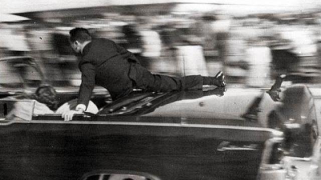 Clint Hill subido a la limusina donde iba John F. Kennedy el día de su asesinato.