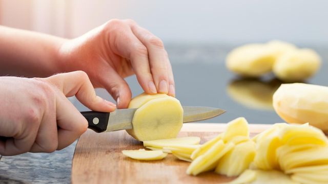 Mujer pelando patatas.