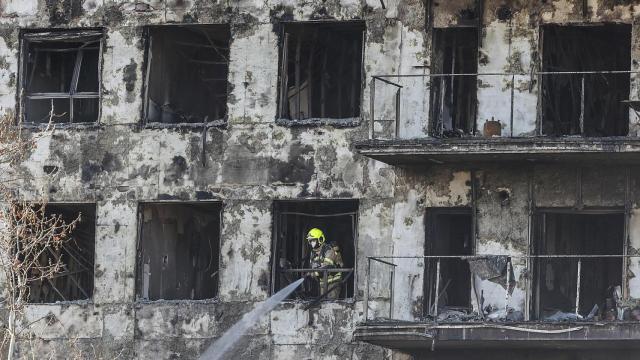 Un agente de la Policía Científica busca las causas del incendio en el edificio del barrio de Campanar. Rober Solsona/Europa Press