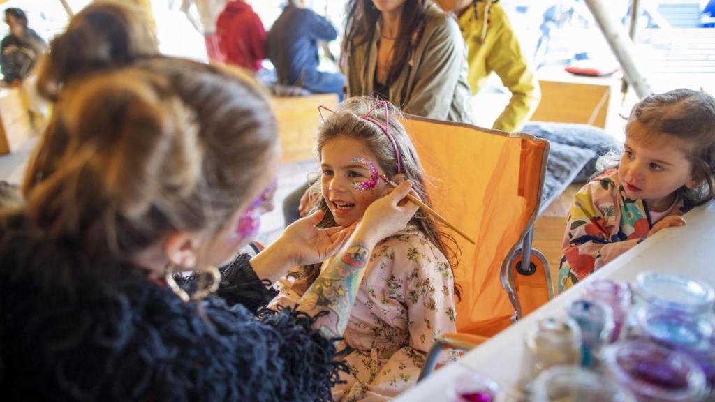 Pintura facial con purpurina en una fiesta de disfraces.