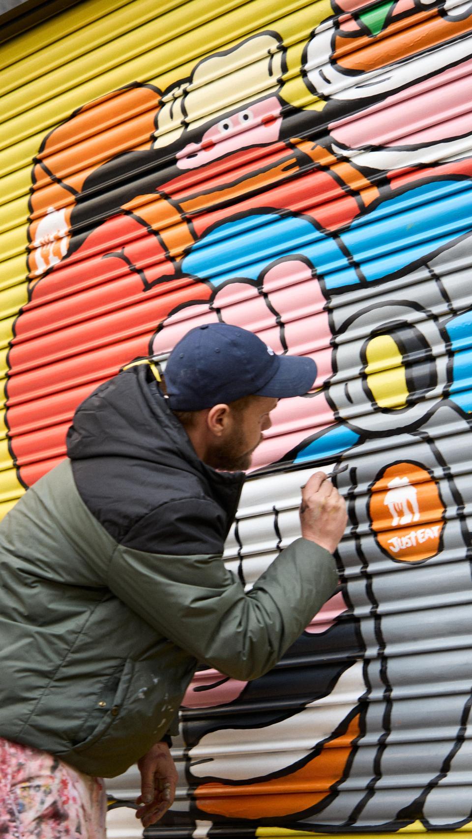 Geco pintando la persiana de Lola's Buger.