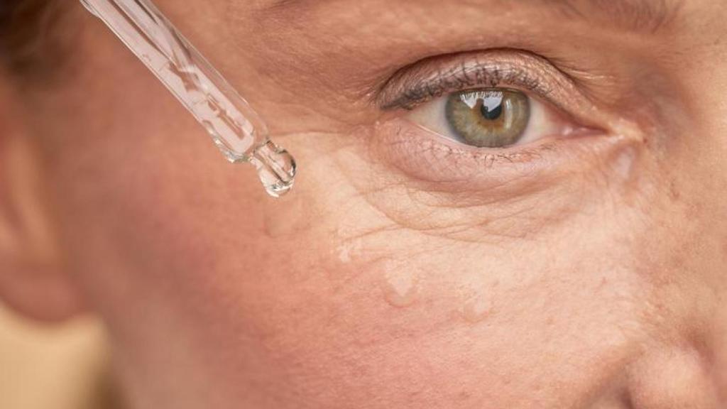 Imagen de una mujer aplicándose serum.