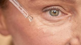 Imagen de una mujer aplicándose serum.