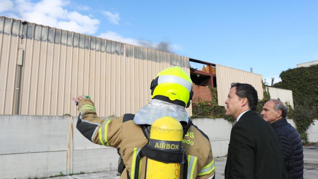 El alcalde de Toledo escucha a un bombero en el lugar del incendio.