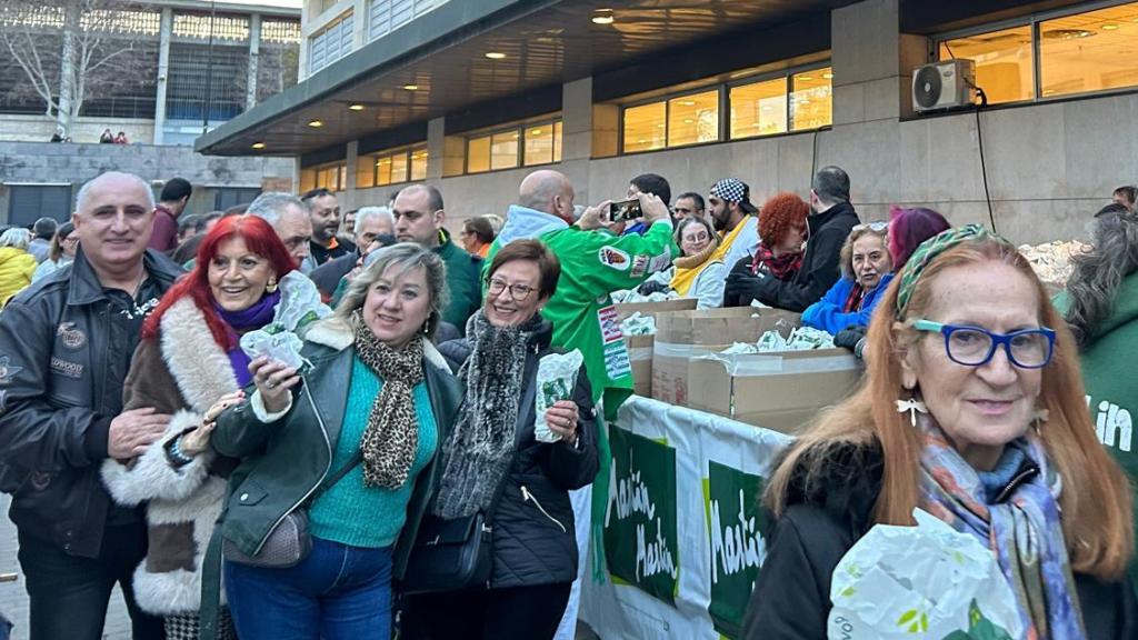 Algunos de los muchos de zaragozanos haciendo fila por el reparto de longaniza.