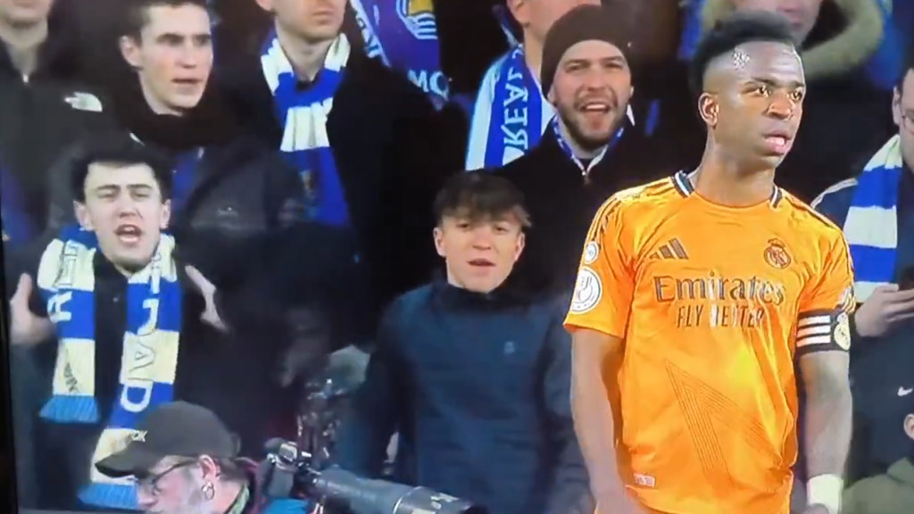 Momento en el que el aficionado de la Real Sociedad hace gestos de mono a Vinicius.