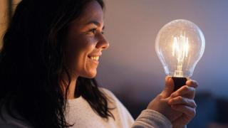 Mujer sujetando una bombilla.