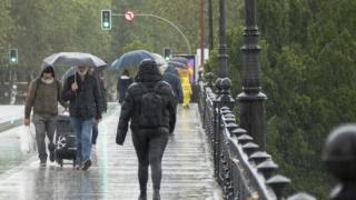 Varias personas se protegen de la lluvia intensa.