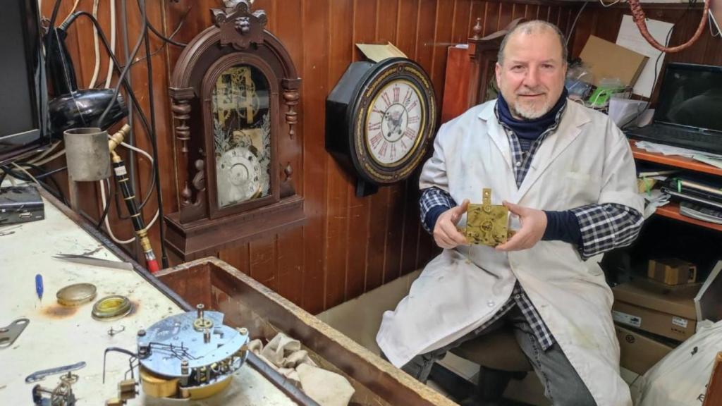 Juan Gómez, con una caja de un reloj de sobremesa de más de 200 años, en la relojería Muiños.