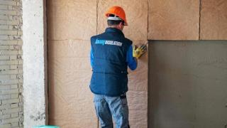 Un operario de Knauf Insolation trabaja en el aislamiento de fachadas.