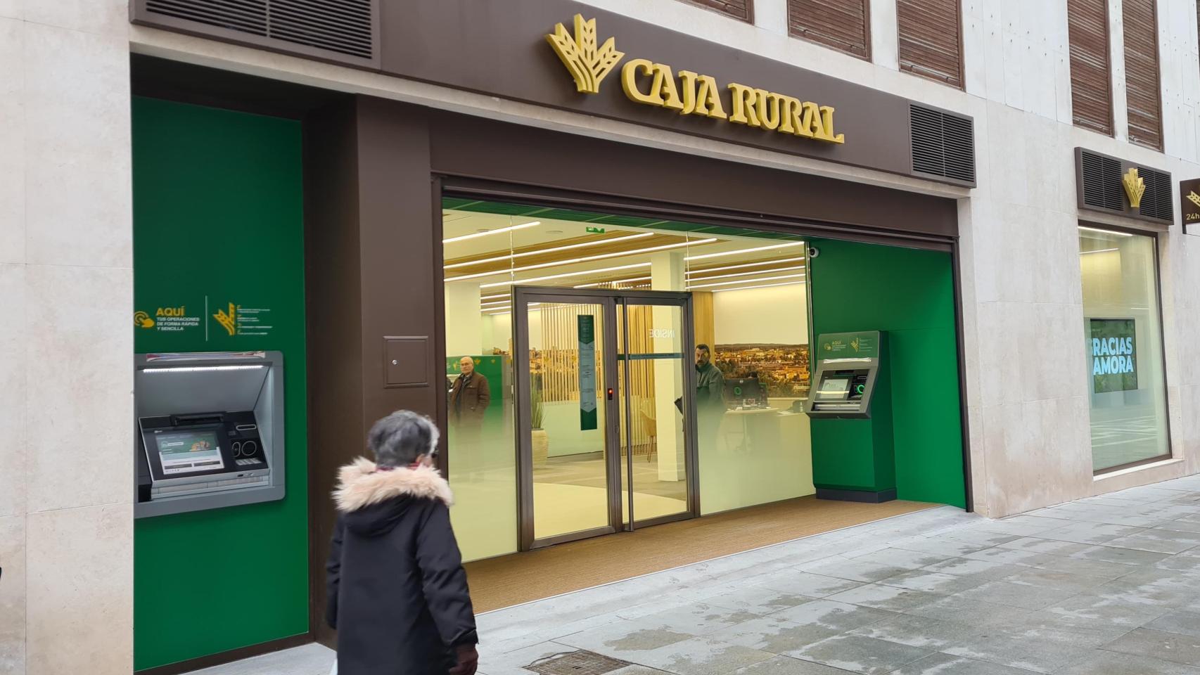 Una mujer mayor pasa frente a una oficina de Caja Rural de Zamora
