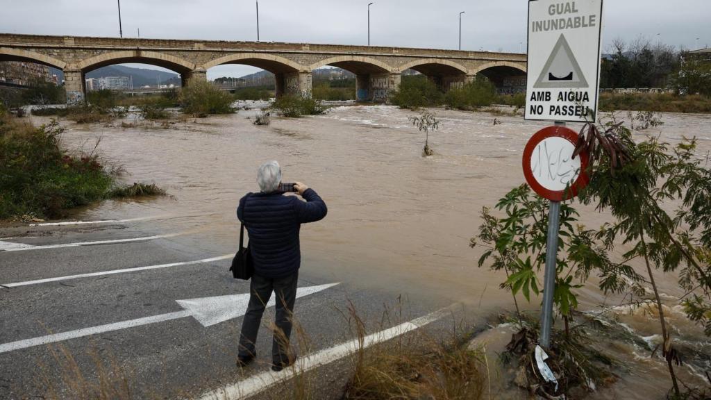 Una persona toma una imagen del caudal del río Palancia a su paso por Sagunto.