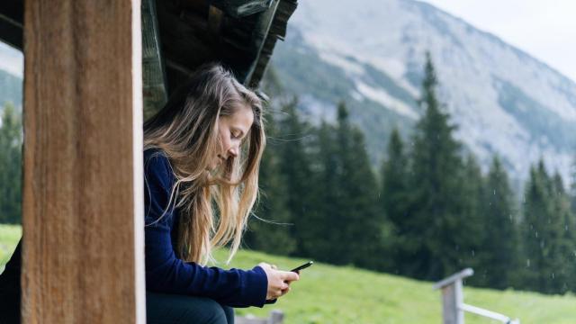 Una mujer utiliza su móvil en un entorno rural