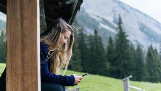 Una mujer utiliza su móvil en un entorno rural