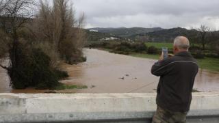 Un hombre fotografía la crecida de un río en Málaga.