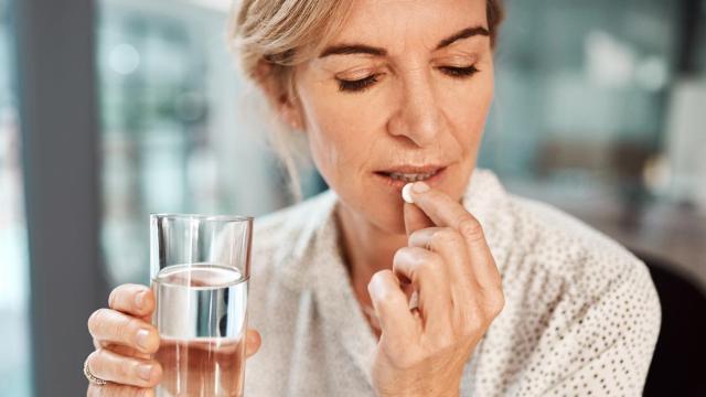 Imagen de una mujer tomándose un suplemento.