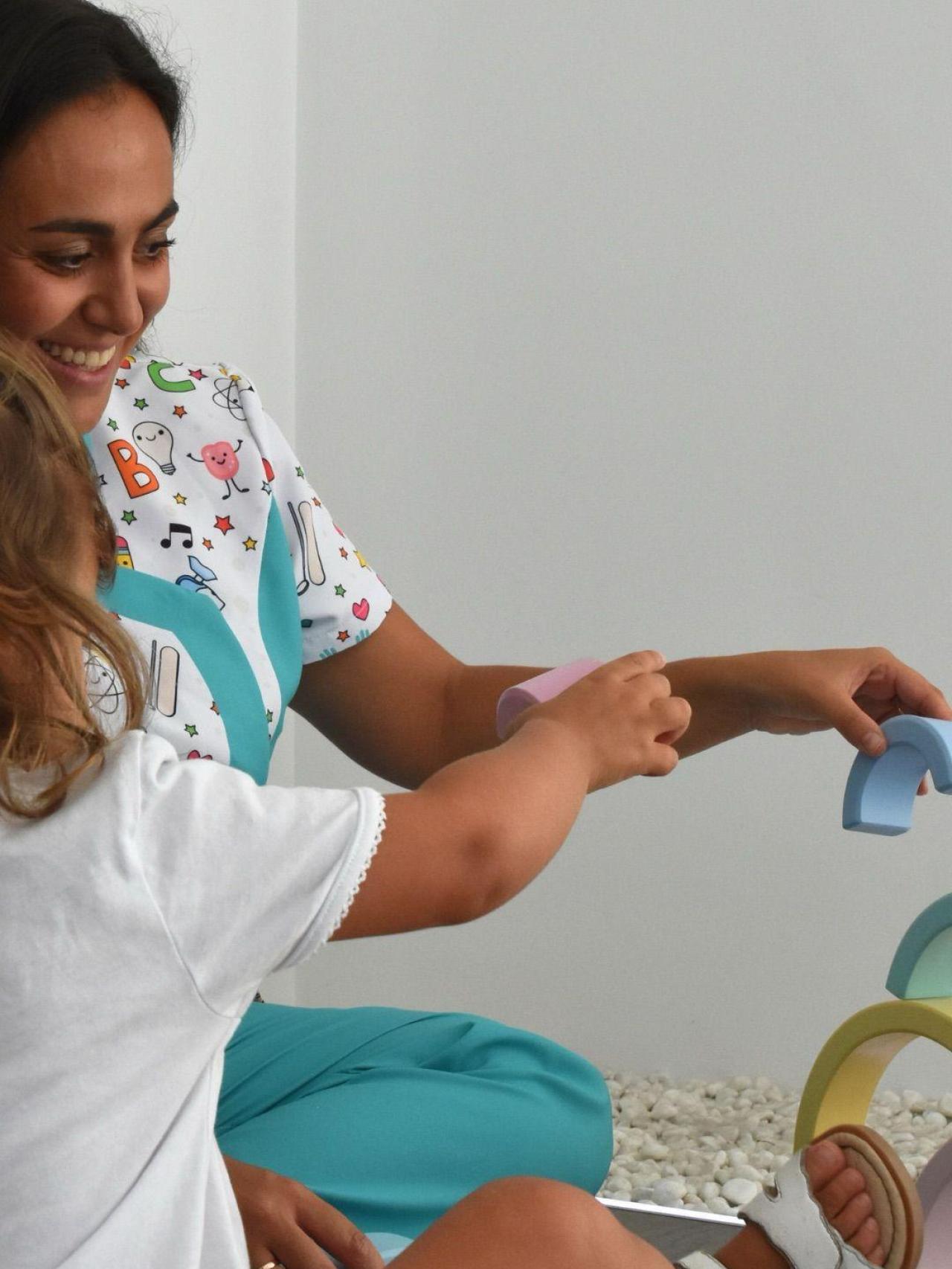 Andrea junto a un niño durante la terapia