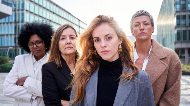 Cuatro mujeres de negocios posan ante la cámara.