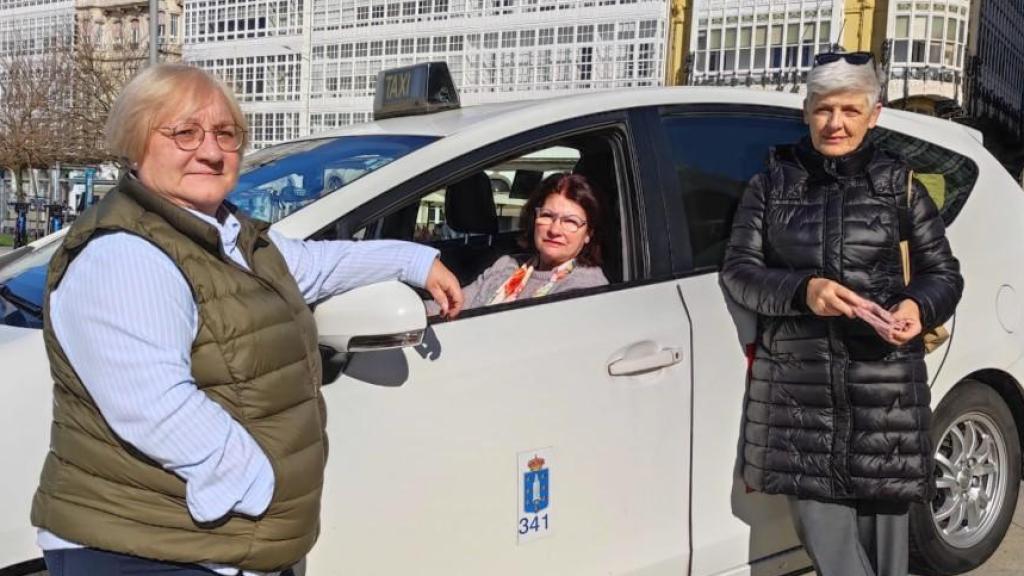 Alicia López Calviño, al volante de un taxi en Puerta Real, entre las taxistas Mari Veira y Maricarmen Valiño.