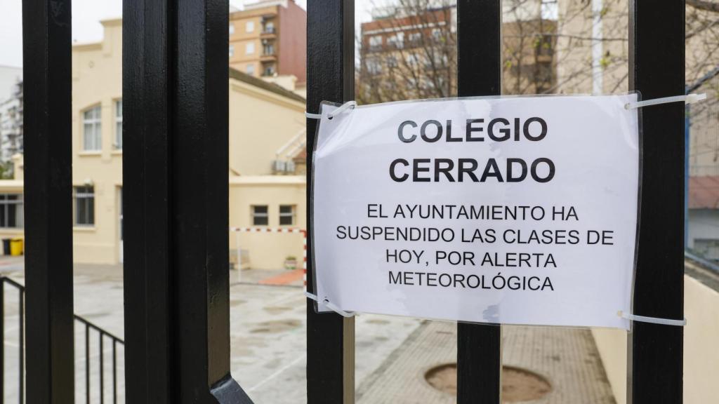 Detalle de un cartel en la puerta de un colegio que anuncia la suspensión de clases durante este jueves ante la alerta meteorológica naranja en la ciudad de València. Efe / Ana Escobar