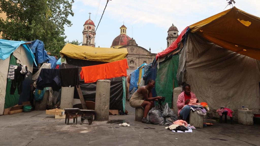 Migrantes haitianas lavan la ropa en el campamento migrante.