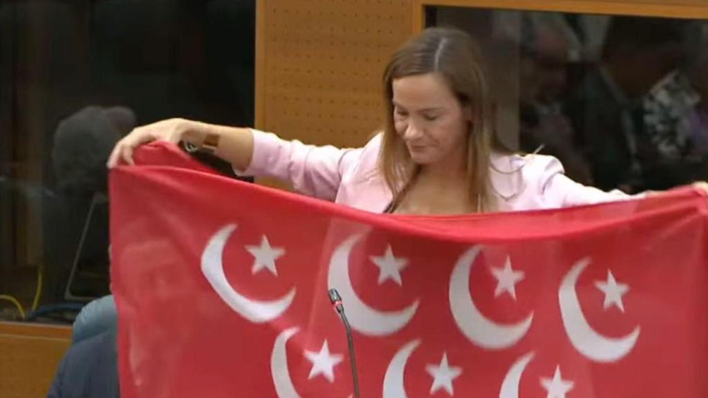 Isabel Pérez Moñino en la Asamblea de Madrid exhibiendo una bandera de Madrid con la media luna en lugar de estrellas el pasado mes de marzo.