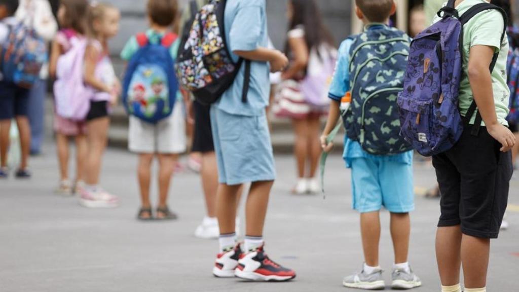 Niños esperando a la entrada de un colegio.
