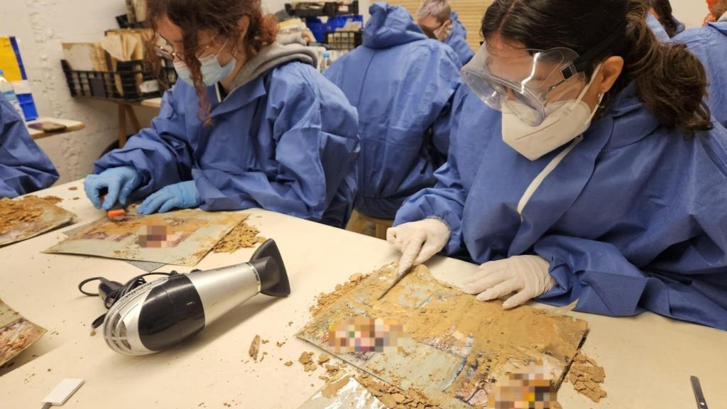 Los estudiantes gallegos limpiando fotos de la dana. EE